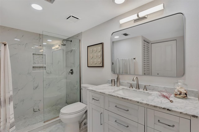 bathroom with toilet, vanity, and tiled shower