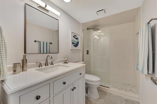 bathroom featuring a tile shower, vanity, and toilet