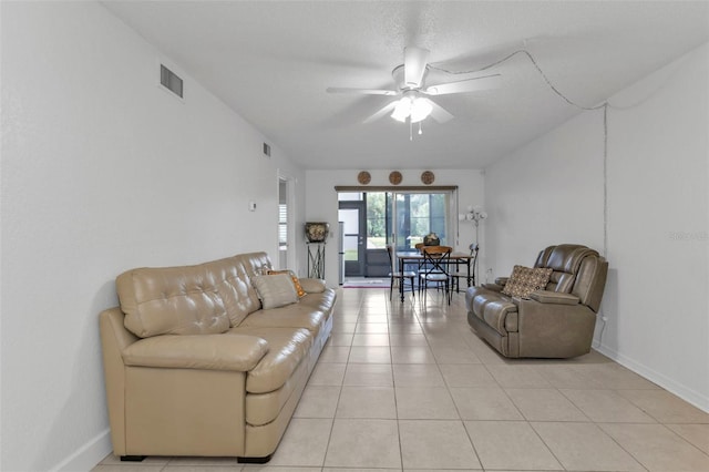 tiled living room with ceiling fan and a textured ceiling