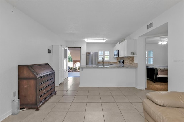 kitchen with light tile patterned floors, white cabinetry, sink, and appliances with stainless steel finishes