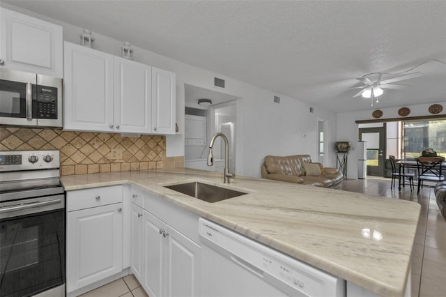 kitchen featuring kitchen peninsula, sink, white cabinets, and appliances with stainless steel finishes