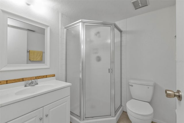 bathroom featuring tile patterned flooring, vanity, toilet, and walk in shower