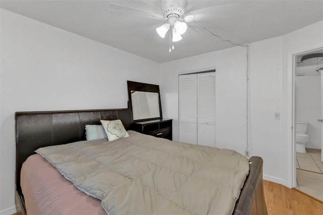 bedroom featuring a textured ceiling, light hardwood / wood-style floors, ensuite bath, and ceiling fan