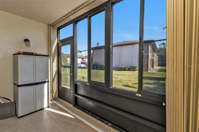 entryway with light tile patterned flooring and a textured ceiling