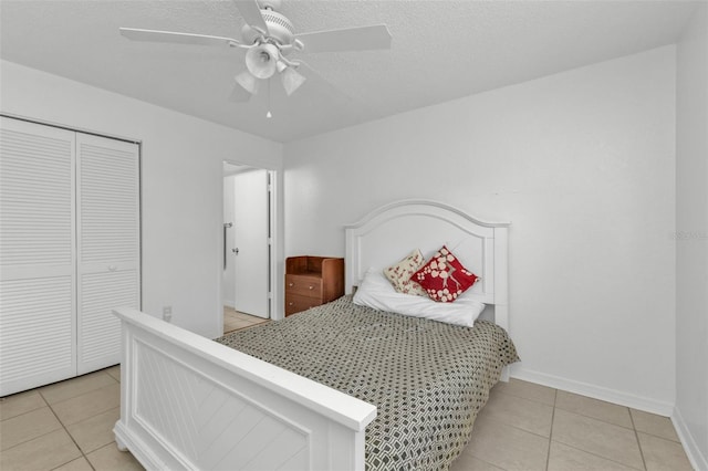 tiled bedroom featuring a textured ceiling, a closet, and ceiling fan