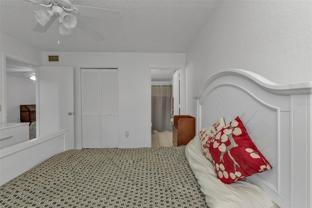 bedroom featuring light tile patterned flooring, a textured ceiling, a closet, and ceiling fan