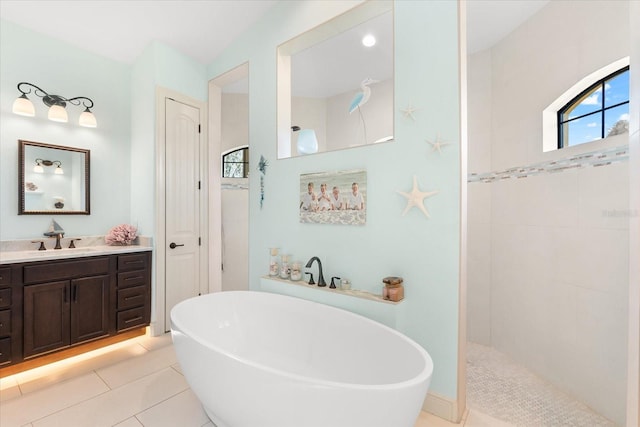 bathroom featuring shower with separate bathtub, vanity, and tile patterned floors