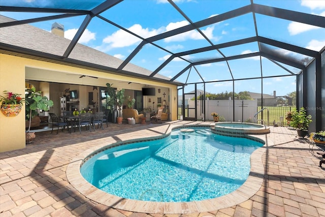 view of pool with ceiling fan, glass enclosure, an in ground hot tub, and a patio