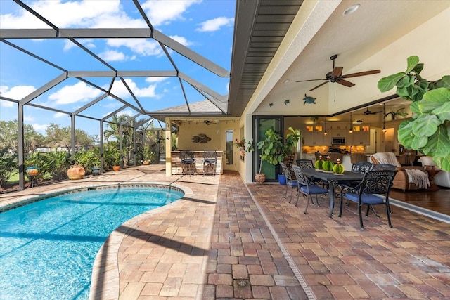 view of pool featuring area for grilling, glass enclosure, ceiling fan, and a patio area