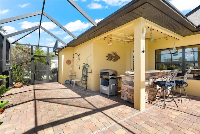 view of patio / terrace featuring a bar, a lanai, and a grill