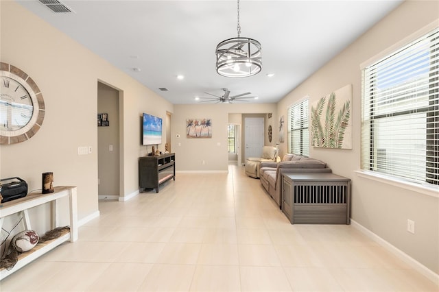 living room with ceiling fan with notable chandelier