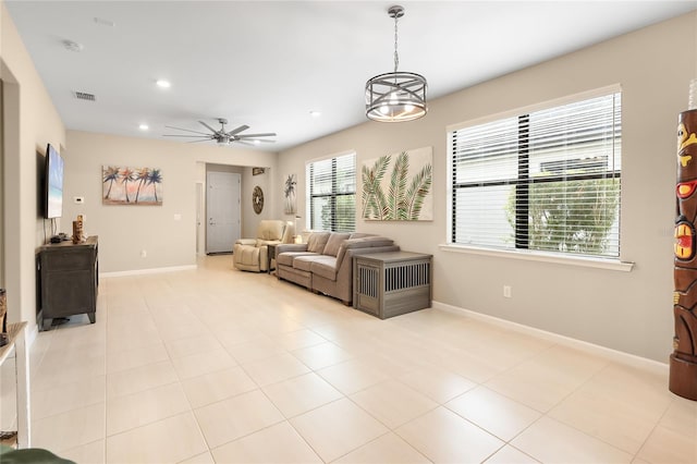 tiled living room featuring ceiling fan with notable chandelier