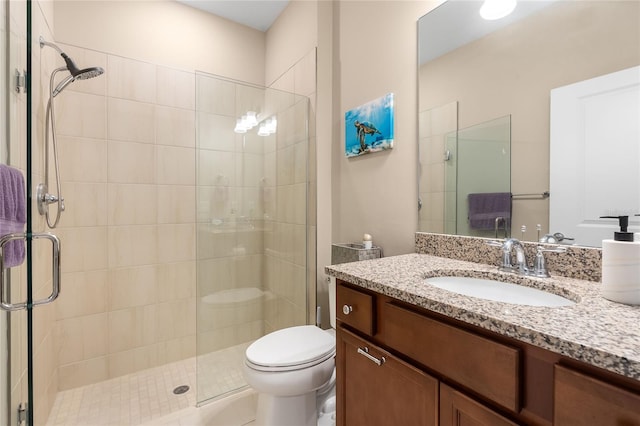 bathroom with vanity, toilet, and a shower with door