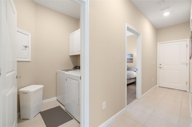 laundry room with separate washer and dryer, light tile patterned flooring, and cabinets