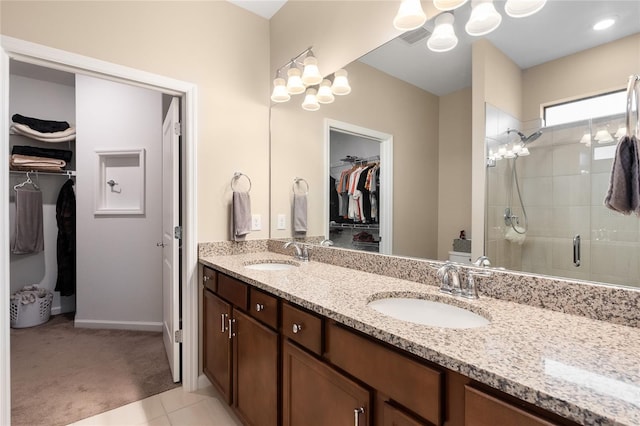 bathroom featuring tile patterned flooring, vanity, and walk in shower