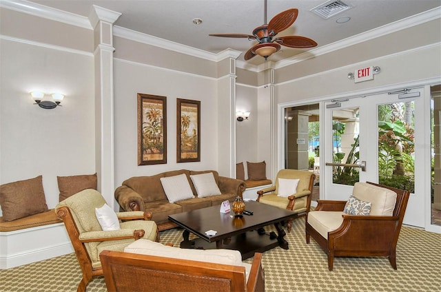 carpeted living room featuring decorative columns, ceiling fan, and crown molding