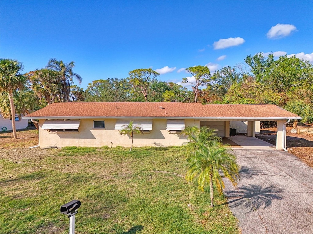 ranch-style home featuring a front lawn and a carport