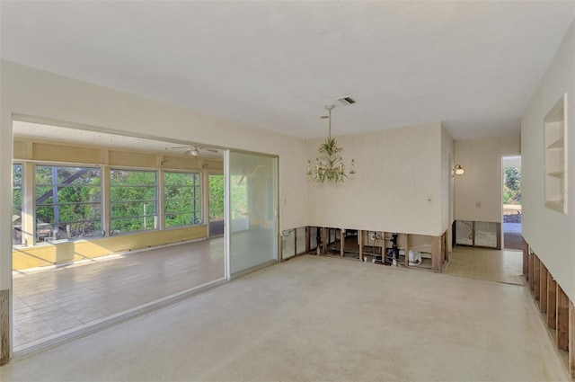 empty room featuring carpet and a chandelier