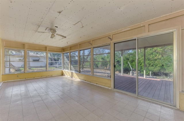 unfurnished sunroom featuring ceiling fan