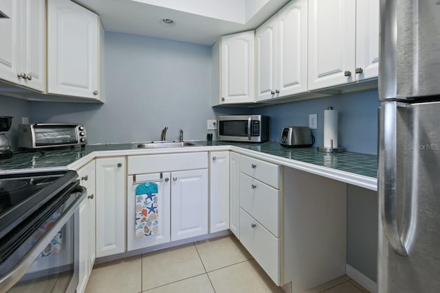 kitchen featuring white cabinets, sink, light tile patterned floors, and stainless steel appliances