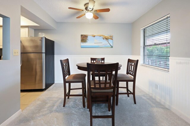 dining room featuring ceiling fan, light tile patterned floors, and a textured ceiling