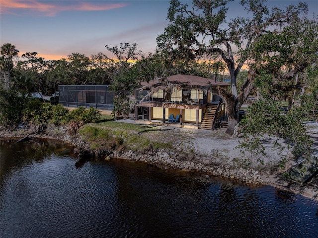 back house at dusk with a water view