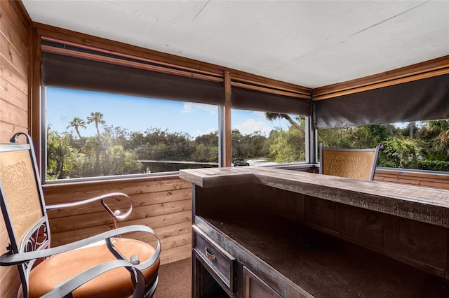 sunroom with a jacuzzi and a healthy amount of sunlight