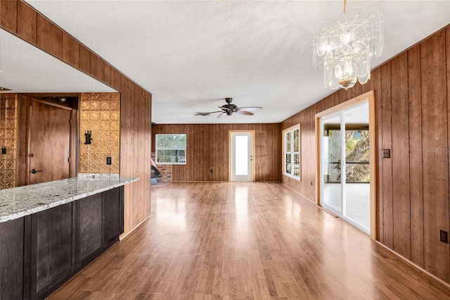 interior space featuring a wealth of natural light, wooden walls, and a textured ceiling