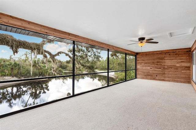 unfurnished sunroom with a water view and ceiling fan