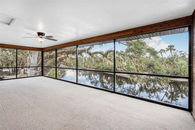 unfurnished sunroom featuring ceiling fan, a water view, and plenty of natural light