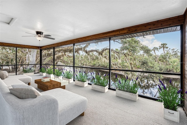 sunroom / solarium featuring a water view, plenty of natural light, and ceiling fan