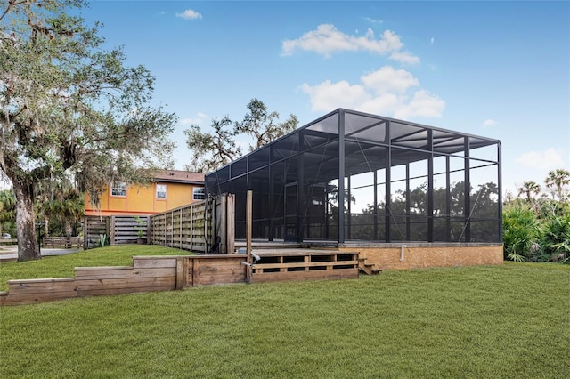 rear view of property featuring glass enclosure and a lawn