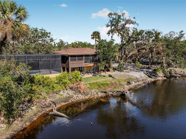 back of house with a lanai and a water view