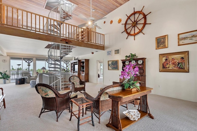 carpeted dining space with ceiling fan, a towering ceiling, and wood ceiling