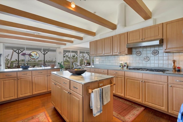 kitchen featuring tasteful backsplash, light hardwood / wood-style floors, stainless steel gas cooktop, a kitchen island, and light brown cabinets