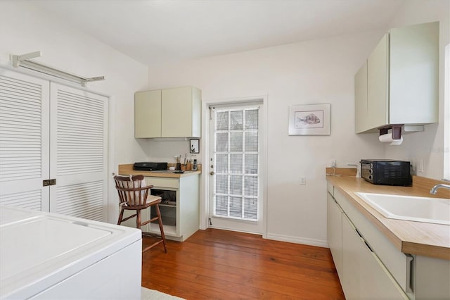 laundry area featuring washer / dryer, sink, and hardwood / wood-style floors