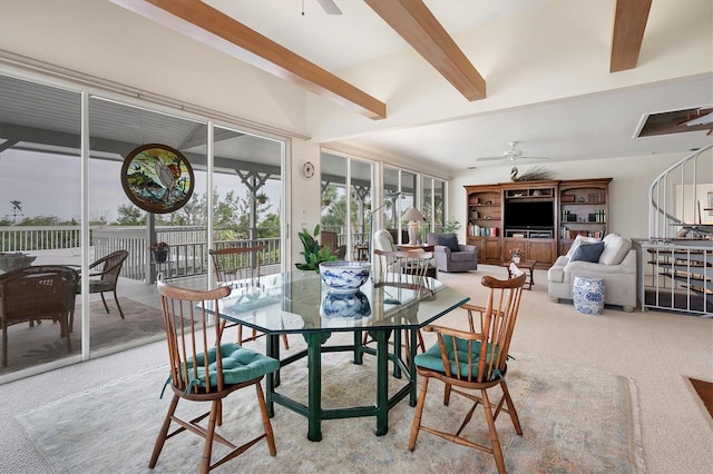 carpeted dining space with beam ceiling and ceiling fan