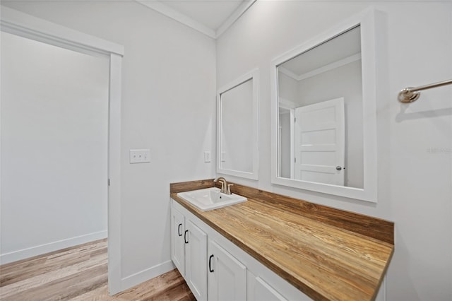 bathroom with hardwood / wood-style flooring, vanity, and ornamental molding