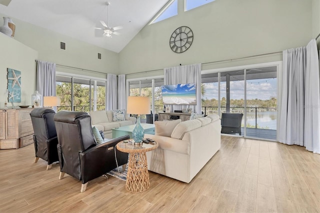 living room with ceiling fan, high vaulted ceiling, and light hardwood / wood-style flooring