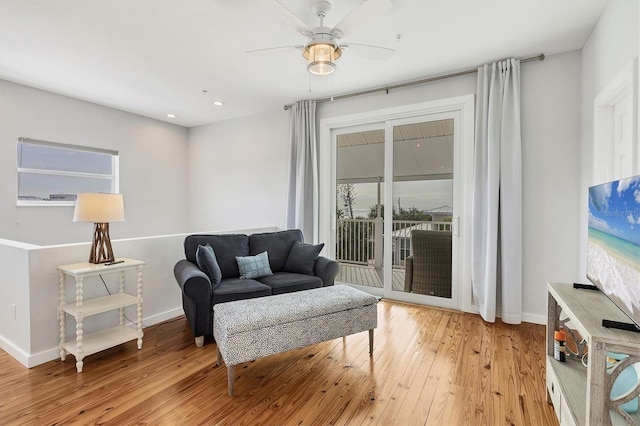 living room with ceiling fan and light hardwood / wood-style flooring