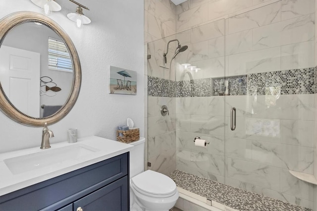 bathroom featuring vanity, toilet, and a shower with door