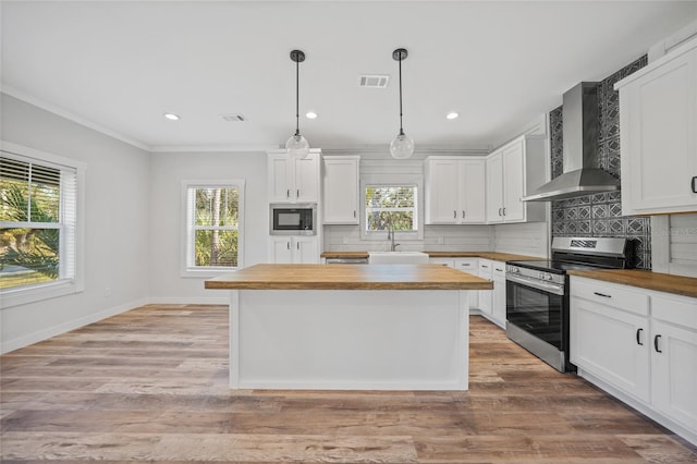 kitchen featuring electric range, wood counters, white cabinetry, and wall chimney range hood