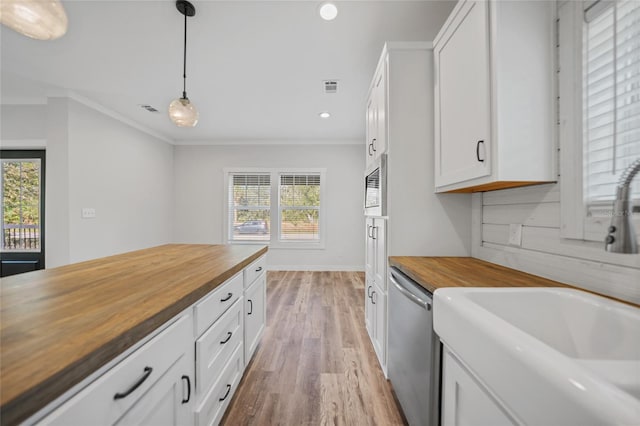 kitchen featuring wood counters, white cabinets, crown molding, appliances with stainless steel finishes, and decorative light fixtures