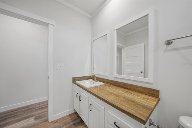 bathroom with vanity, hardwood / wood-style flooring, and crown molding