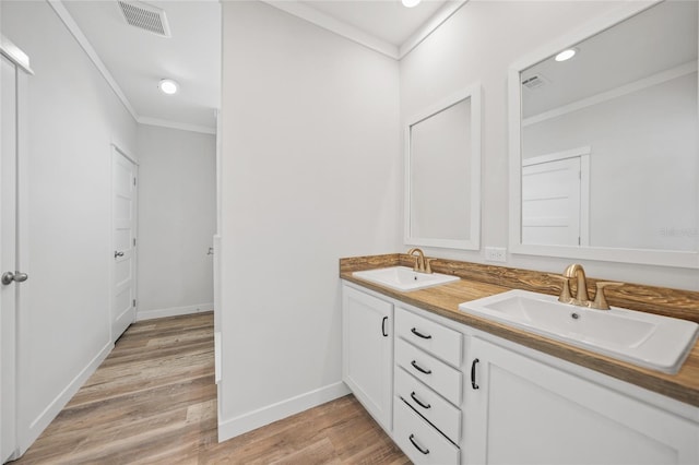 bathroom featuring hardwood / wood-style floors, vanity, and crown molding