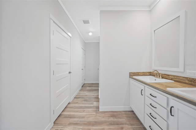 bathroom featuring crown molding, hardwood / wood-style floors, and vanity