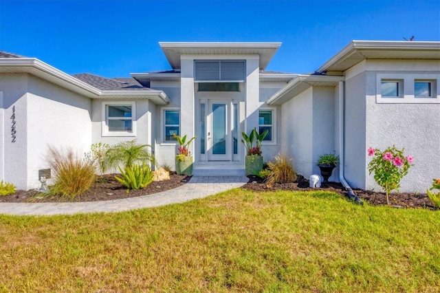 property entrance featuring a lawn