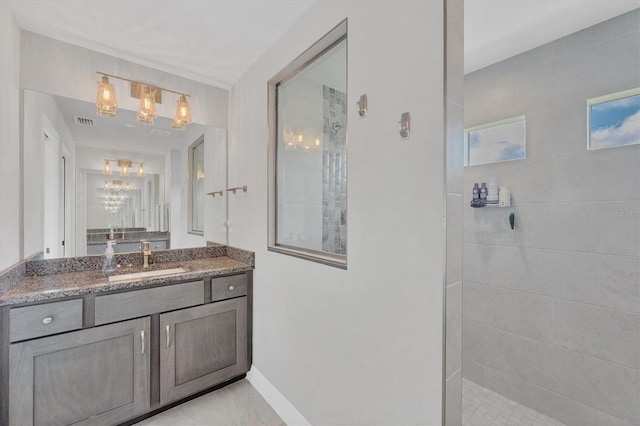 bathroom featuring a tile shower, tile patterned floors, and vanity