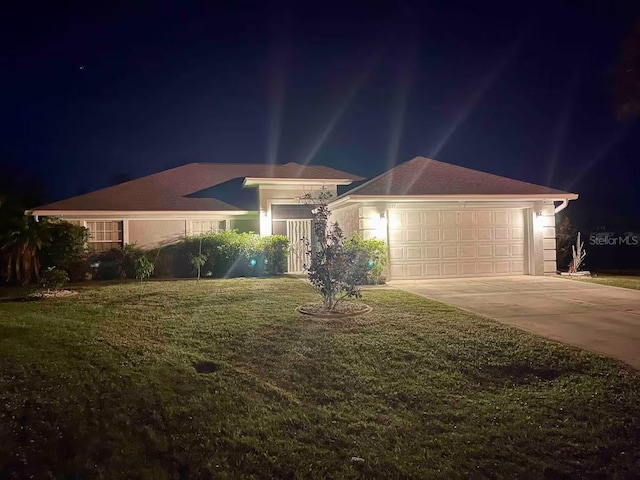 ranch-style house with a garage and a yard