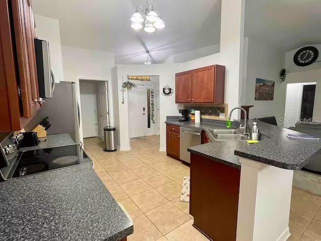 kitchen with sink, an inviting chandelier, kitchen peninsula, light tile patterned floors, and appliances with stainless steel finishes